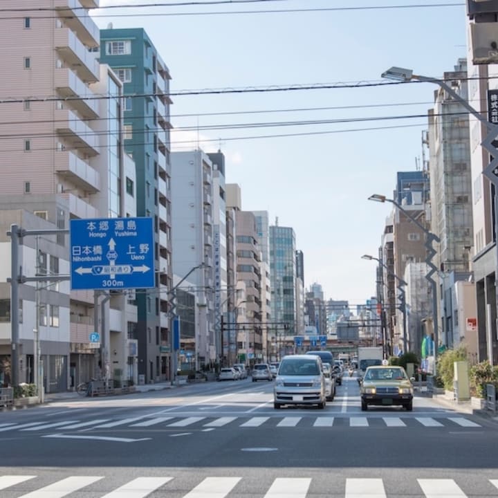地域密着の賃貸サービスを象徴する、日本の都市の街並みと道路標識